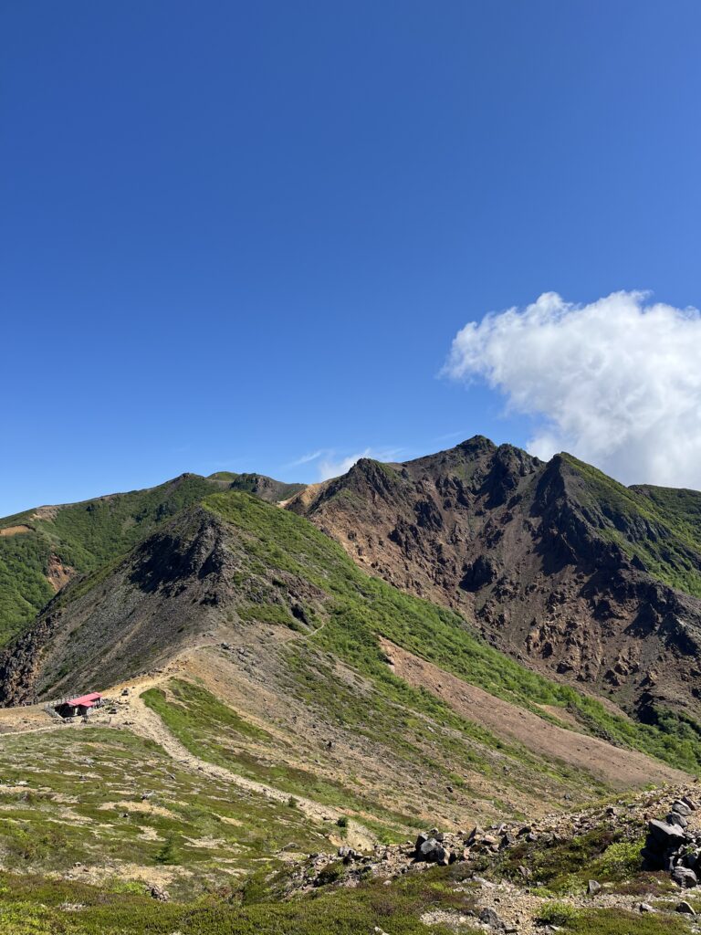 那須連山を形成する茶臼岳から朝日岳方面を望む。火山由来の赤褐色の山肌と緑のコントラストが美しい。
那須連山に訪れた際に必ず見たい絶景。